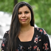 Portrait of Maria Quintero smiling at the camera.